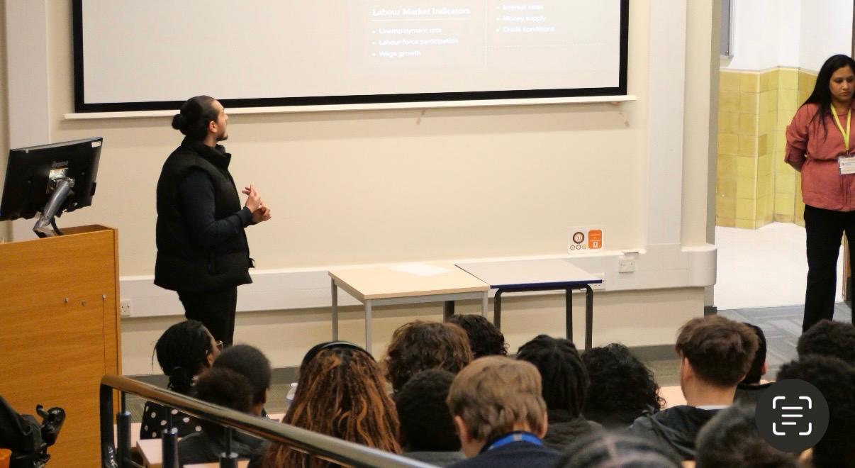 Wandsworth College lecture theatre with labour market indicators on screen